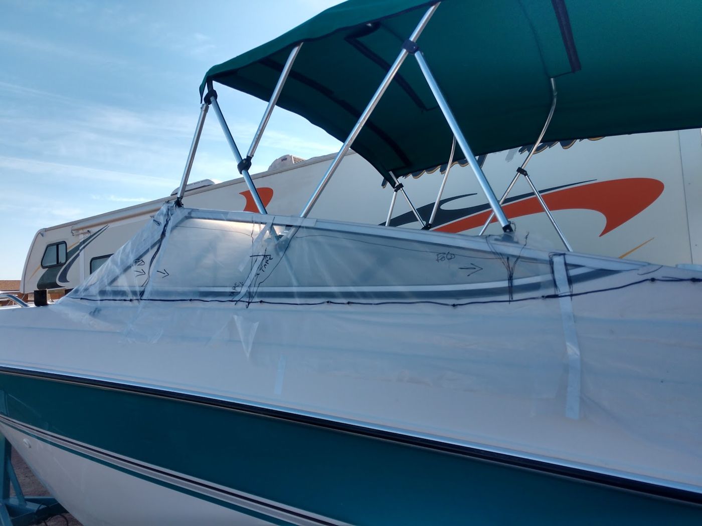 A boat on a trailer with a canvas cover