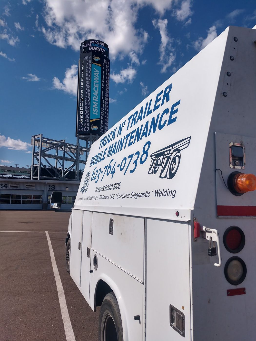 The service van under a blue sky with the company name and phone number on the side